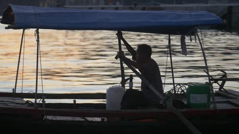 Silhoutted-Man-on-Traditional-Vietnamese-Boat