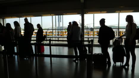 Silhouetted-Passengers-Queuing-in-Airport