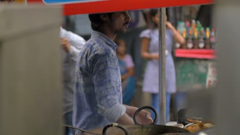 Hombre-preparando-comida-india-tradicional-de-la-calle