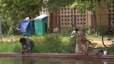 Indian-Men-Wash-Their-Feet-by-a-Pond