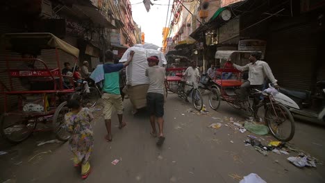 Men-Pushing-Cart-Down-Busy-Street-