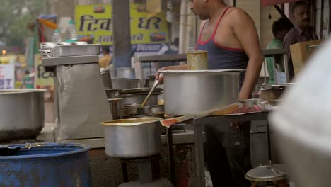 Man-Adds-Spices-to-Food-at-a-Stall
