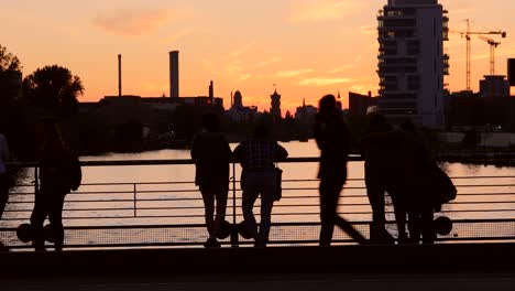 Silhouetted-Tourists-Overlooking-River-at-Sunset