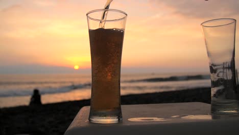 Pouring-Beer-in-a-Glass-on-a-Beach-at-Sunset