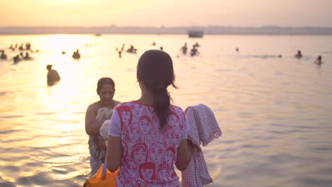Girl-Handing-Towel-to-Woman-in-the-Ganges