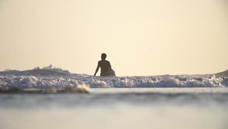Tiro-bajo-de-un-surfista-caminando-en-el-mar
