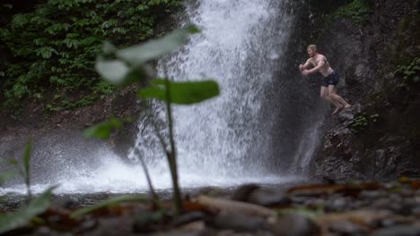 Man-Jumping-from-a-Ledge-into-a-Waterfall