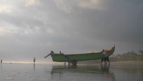 Hombres-haciendo-rodar-una-canoa-de-pesca-hacia-el-mar