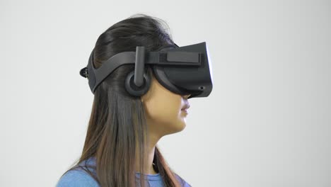 Mujer-joven-mirando-a-su-alrededor-en-casco-de-realidad-virtual