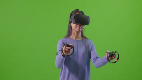 Junge-Dame-Spielt-VR-Spiel-Vor-Grünem-Bildschirm