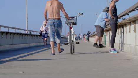 Man-Wheeling-Bike-Down-Pier