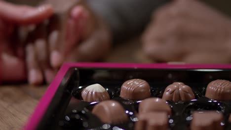 Choosing-Heart-Shaped-Chocolates-from-Box
