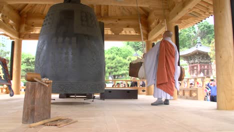 Buddhist-Monk-Striking-Large-Bell