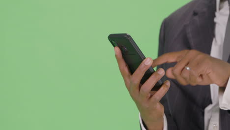 CU-Businessman-takes-out-phone-and-texts-on-green-screen