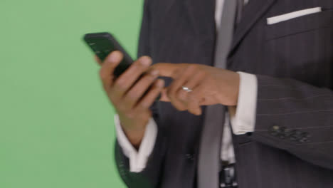 CU-Businessman-texting-while-walking-on-green-screen