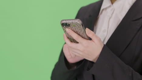 CU-Businesswoman-takes-out-phone-and-texts-on-green-screen