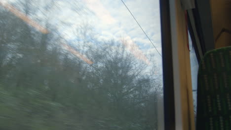 Looking-out-at-sky-from-moving-train-exiting-tunnel