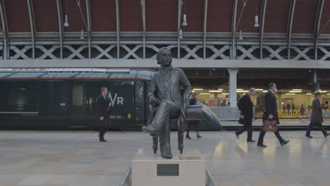 Commuters-pass-statue-on-train-platform
