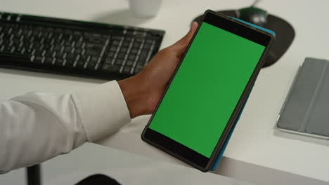 CU-Man-at-Desk-Holds-Tablet-with-Green-Screen