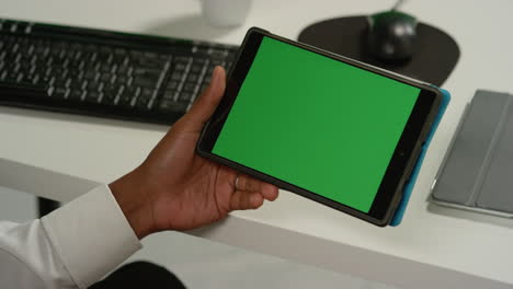 CU-Man-en-el-escritorio-con-tableta-con-pantalla-verde