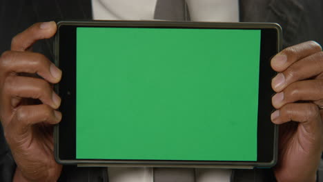 CU-Man-Holds-Tablet-at-Camera-with-Green-Screen