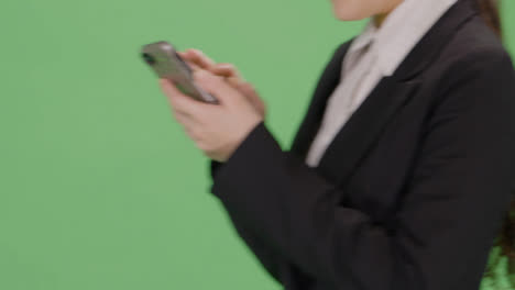 CU-Businesswoman-texting-while-walking-on-green-screen