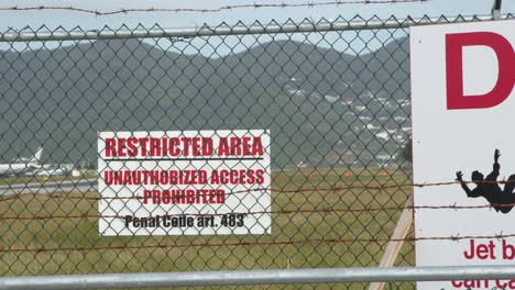 Signs-on-Airport-Perimeter-with-Plane-in-BG