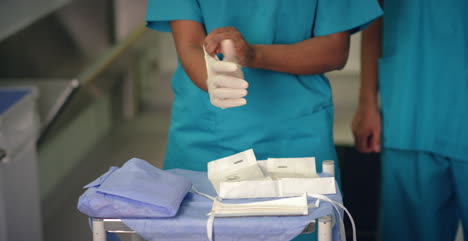 Female-Medic-Putting-On-Surgical-Gloves