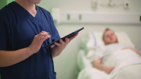 CU-Male-Nurse-Making-Notes-on-Tablet
