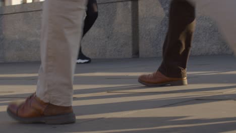 Close-Up-Of-Feet-Walking-On-Pavement