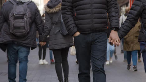 Couples-Holding-Hands-Walking-In-Street,-defocused