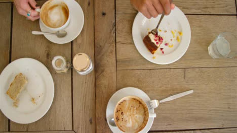 Draufsicht-Der-Hände,-Die-Kaffeetassen-Und-Kuchen-Vom-Café-Tisch-Heben