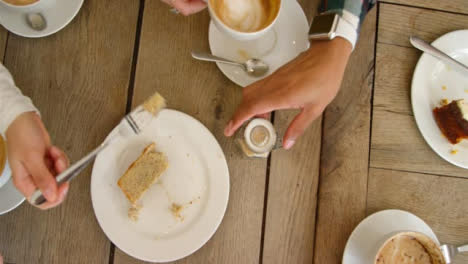 Draufsicht-Der-Hände,-Die-Tassen-Kaffee-Und-Kuchen-Vom-Café-Tisch-Heben