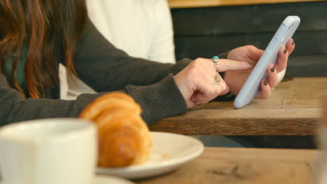 Woman-Using-Teléfono-in-Cafe