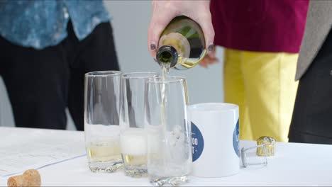 Close-Up-Pouring-Champagne-Into-Cups-And-Glasses-In-Office