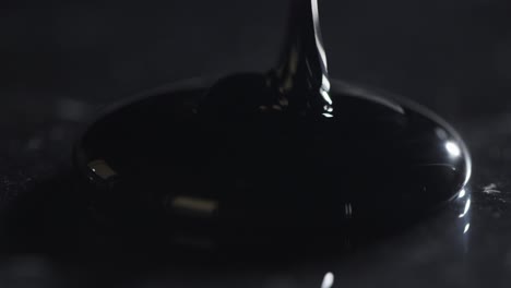 Oil-Being-Poured-onto-Black-Surface