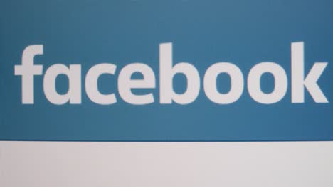 Close-Up-Pan-of-Facebook-logo-on-screen