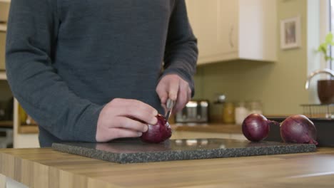Man-Chopping-Onions-in-Kitchen