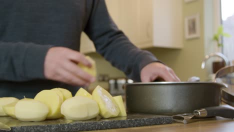Man-Putting-Potatoes-in-Pot-in-Kitchen