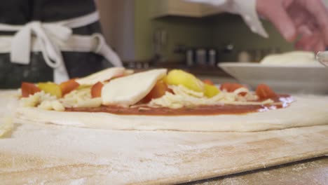 Close-Up-Putting-Mozzarella-on-Pizza-Dough