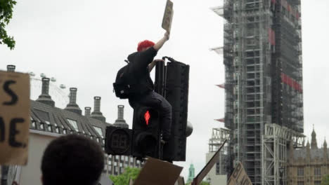 London-Black-Lives-Matter-Protester-Sitting-Above-Crowds-On-Traffic-Light