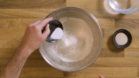Top-View-Pouring-Yeast-and-Salt-into-Bowl