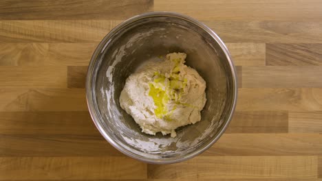 Top-View-Pouring-Olive-Oil-into-Sticky-Dough