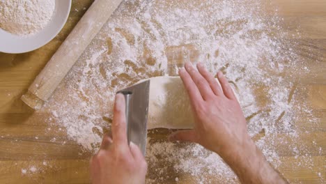 Top-View-Male-Cuts-Dough-Using-Dough-Scraper