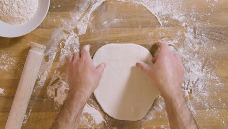 Top-View-Male-Hand-Stretching-Dough