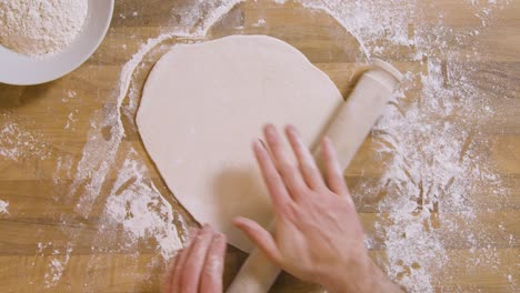 Top-View-Male-Using-Rolling-Pin-on-Dough
