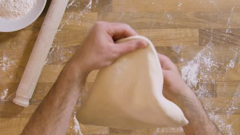 Top-View-Male-Stretches-and-Shapes-Pizza-Dough-