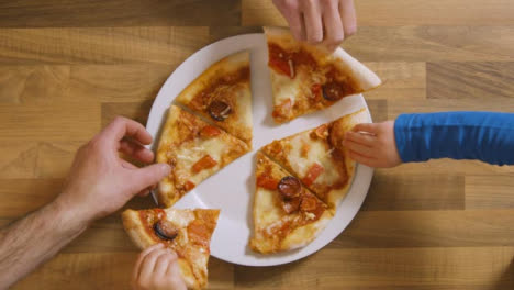 Draufsicht-Familie-Nimmt-Jedes-Stück-Pizza