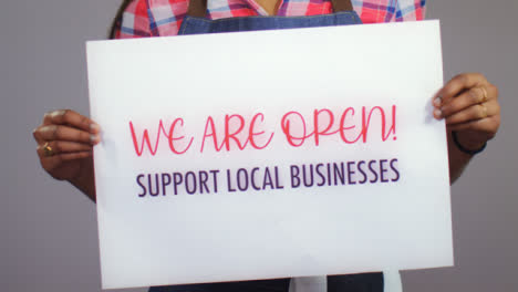 Close-Up-of-Woman-Holding-Support-Local-Business-Sign