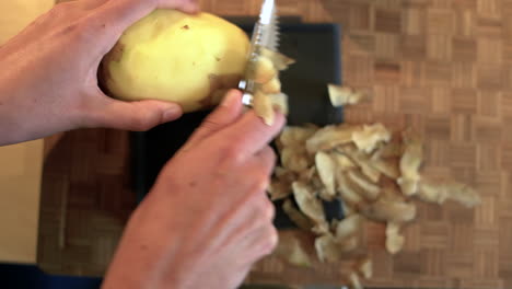 POV-Shot-of-Female-Hands-Peeling-a-Potato-